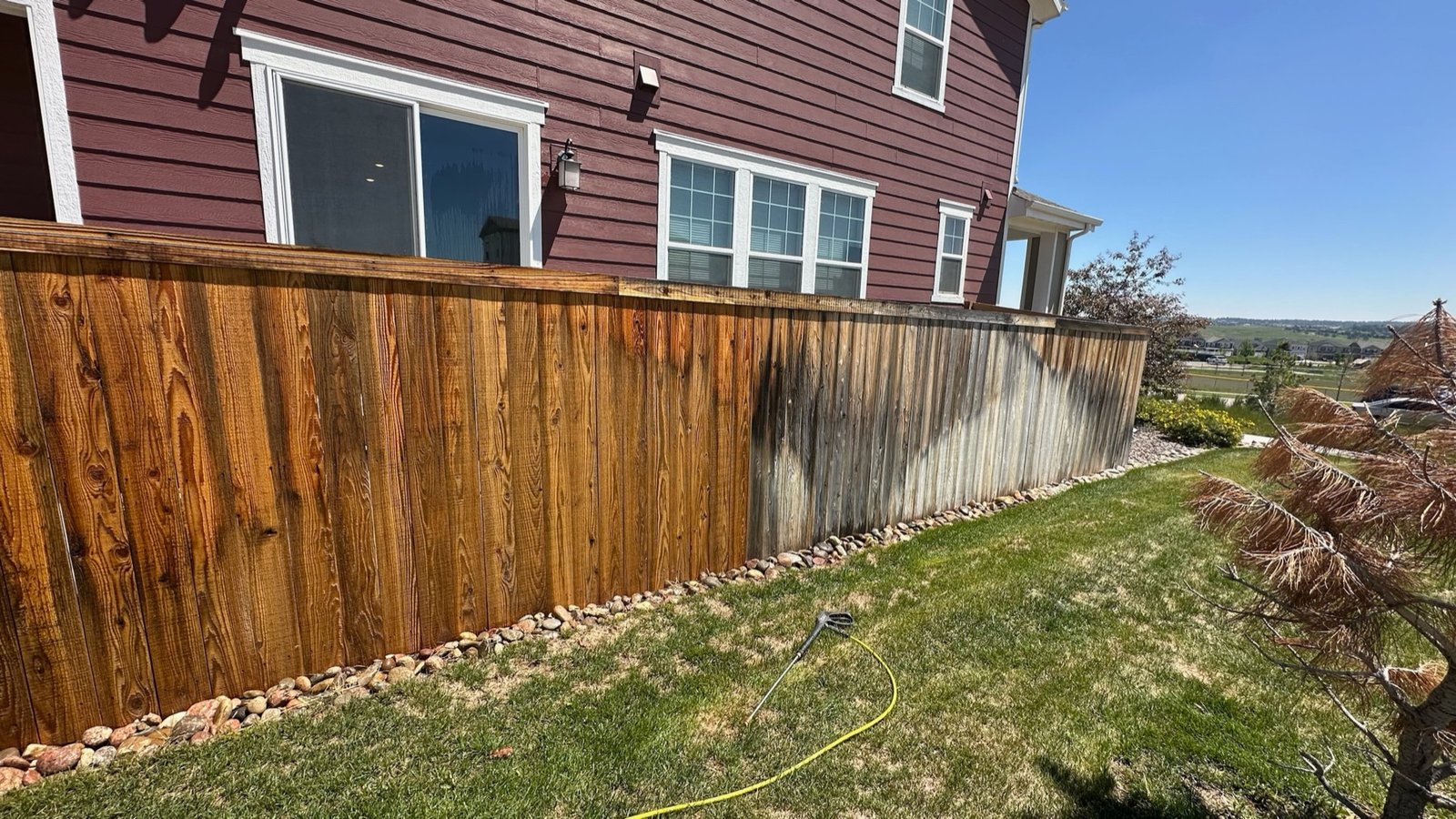 Hail, Sun, and Freeze: The Front Range Home Exterior Exposure Guide 2 A wood fence half cleaned showing weathered gray next to restored boards